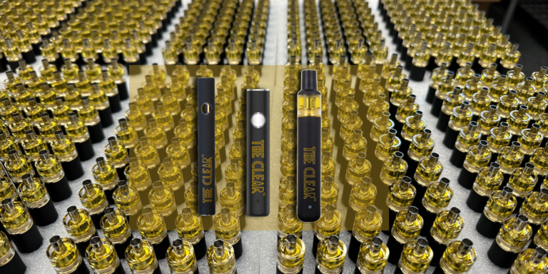 Neatly arranged in clusters are a plethora of cartridges filled with THC distillate. An overlay of The Clear cannabis vape pen batteries can be seen in the center. The vape batteries from left to right are The Clear dual voltage 510 thread battery, The Clear 14mm vape pen battery, and The Clear Elite All-In-One THC Vape.